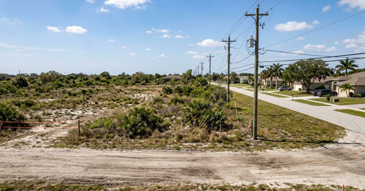 Postes de energia elétrica ao longo de uma estrada em área residencial da Flórida — acesso a utilidades como luz, água e esgoto impacta diretamente o valor e o potencial de construção do terreno
